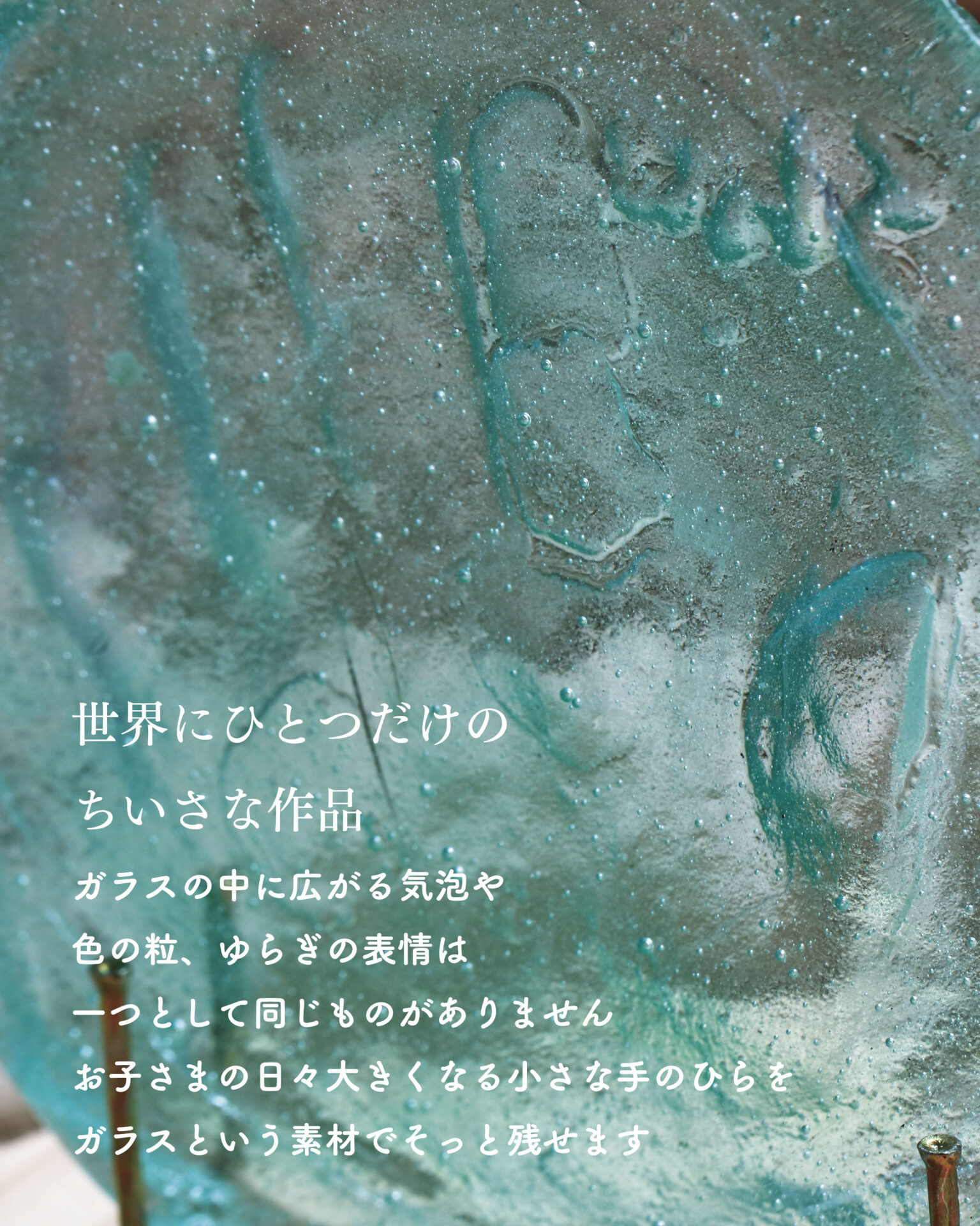 ガラスの中に気泡や色のゆらぎが広がる手形作品